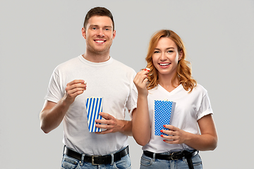 Image showing happy couple in white t-shirts eating popcorn