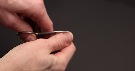 Image showing Man cuts fingernail for himself