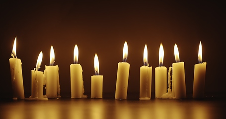 Image showing Candles glowing against dark background