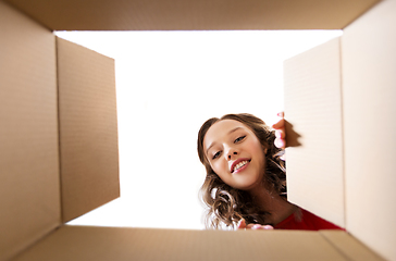 Image showing happy young woman looking into open gift box