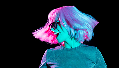 Image showing happy woman in pink wig and sunglasses dancing