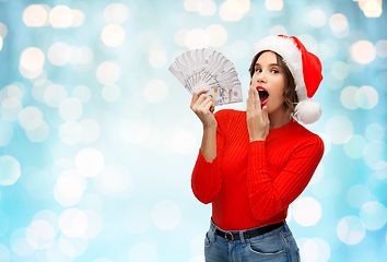 Image showing surprised woman in santa hat with money