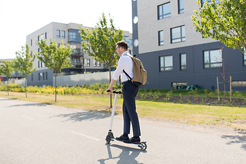 Image showing businessman with backpack riding electric scooter