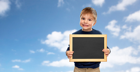 Image showing little boy with black blank chalkboard over sky