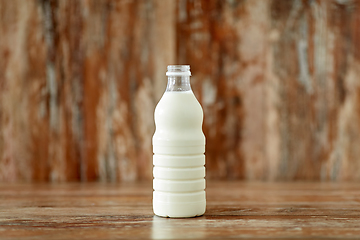 Image showing bottle of milk on wooden table