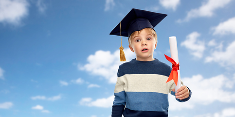 Image showing little boy in mortarboard with diploma over sky