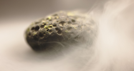 Image showing Smoke whirling around small meteorite stone