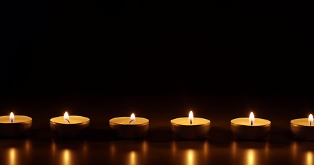 Image showing Candles glowing against dark background