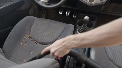 Image showing Man cleaning dirty car interior with vacuum cleaner