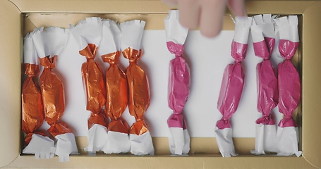 Image showing Man and woman picking out christmas chocolate from box