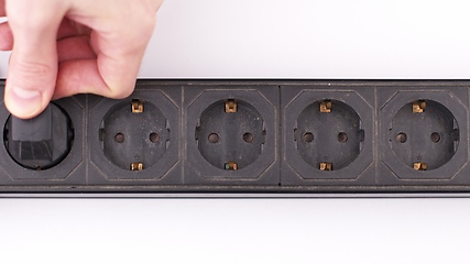 Image showing Filling Electric socket holes with electric plugs closeup footage