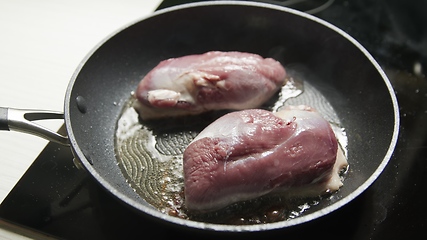 Image showing Roast duck breast in frying pen closeup footage