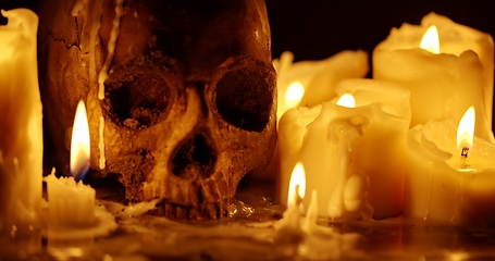 Image showing Candles and human skull in darkness closeup footage