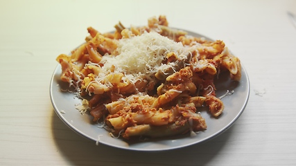 Image showing Cheese topping beiing applied to bowl of pasta