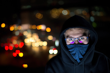 Image showing hacker using laptop computer while working in dark office