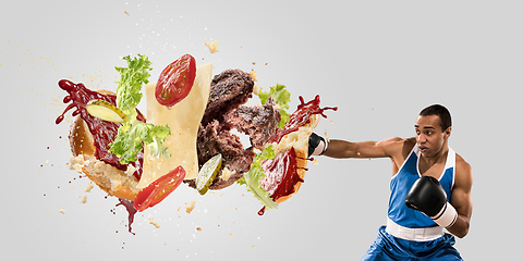 Image showing Burger\'s crashing by the boxer isolated on white background