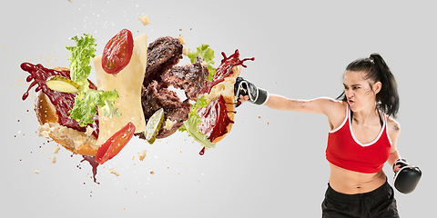 Image showing Burger\'s crashing by the boxer isolated on white background