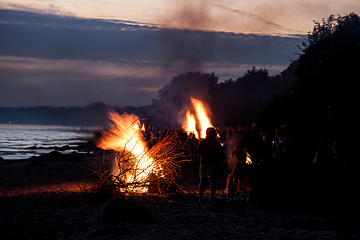 Image showing Unrecognisable people celebrating summer solstice with bonfires on beach