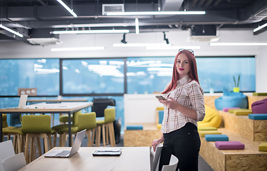 Image showing redhead businesswoman using mobile phone at office