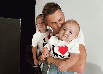 Image showing Happy father holding adorable little sons and smiling