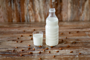 Image showing milk and almonds on wooden table