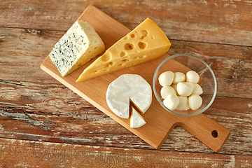 Image showing different kinds of cheese on wooden cutting board