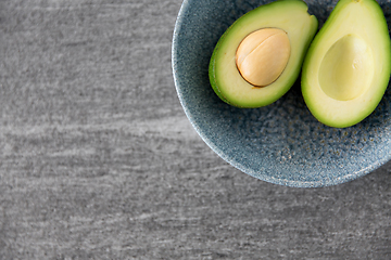 Image showing close up of ripe avocado with bone in ceramic bowl