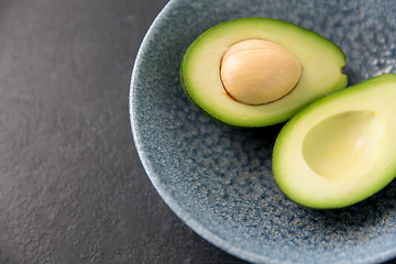 Image showing close up of ripe avocado with bone in ceramic bowl