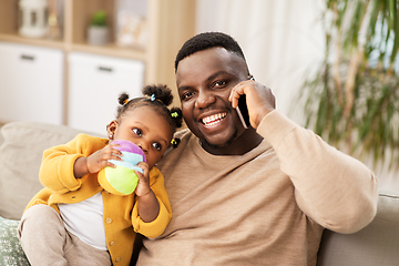 Image showing father with baby at home calling on smartphone