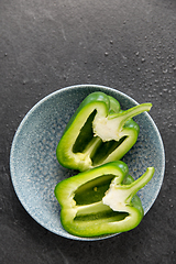 Image showing cut green pepper in bowl on slate stone background