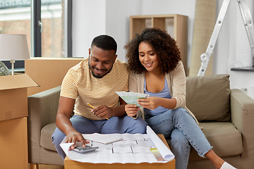 Image showing couple with blueprint counting money at home