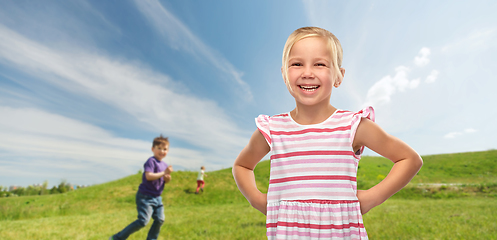 Image showing smiling little girl in striped dress outdoors