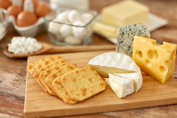 Image showing crackers, cheese and other food on wooden board