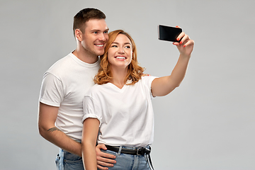 Image showing happy couple in white t-shirts taking selfie