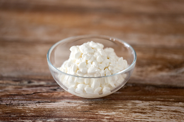 Image showing close up of cottage cheese in bowl on wooden table