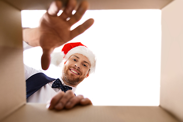 Image showing happy young man looking into open christmas gift