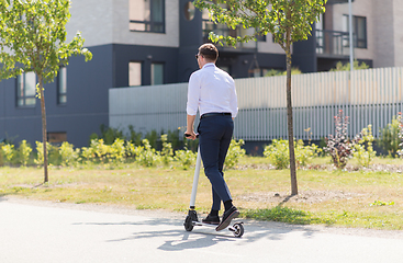 Image showing young businessman riding electric scooter outdoors