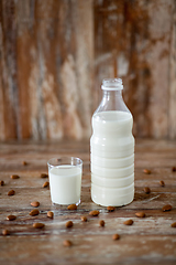 Image showing milk and almonds on wooden table
