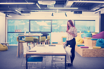 Image showing redhead businesswoman using mobile phone at office