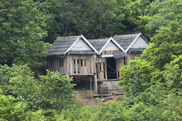 Image showing Three old shacks in the forest