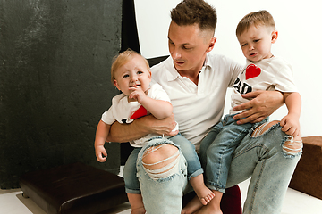 Image showing Happy father holding adorable little sons and smiling