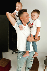 Image showing Happy father holding adorable little sons and smiling