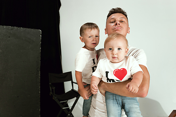 Image showing Happy father holding adorable little sons and smiling