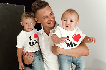 Image showing Happy father holding adorable little sons and smiling