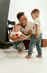 Image showing Happy father holding adorable little sons and smiling