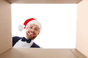 Image showing happy young man looking into open christmas gift