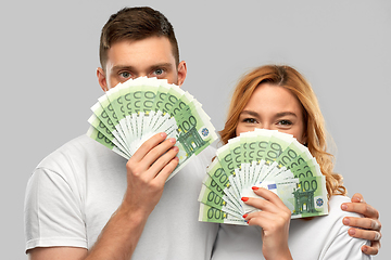 Image showing happy couple in white t-shirts with euro money