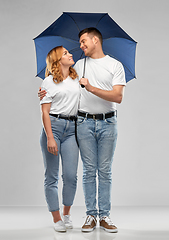 Image showing happy couple in white t-shirts with umbrella