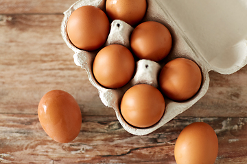 Image showing close up of eggs in cardboard box on wooden table