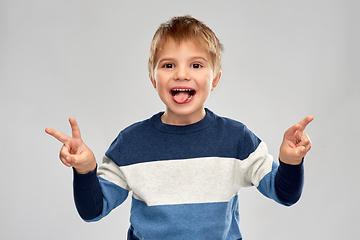 Image showing little boy in striped pullover showing peace